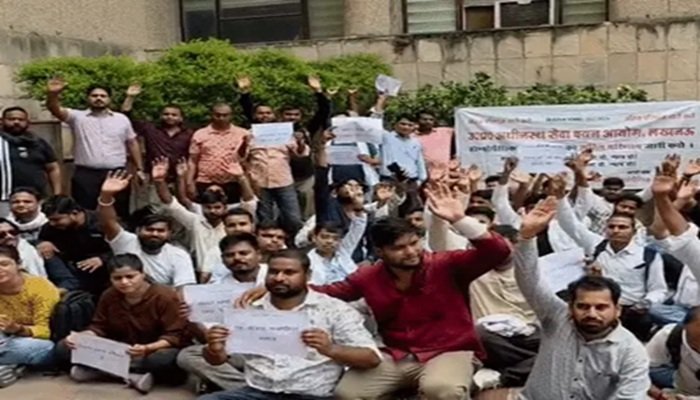 लखनऊ में UPSSSC मुख्यालय पर प्रदर्शन, जमीन पर बैठे होम्योपैथिक फार्मासिस्ट अभ्यर्थी